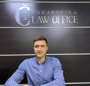 Damjan in front of law office sign