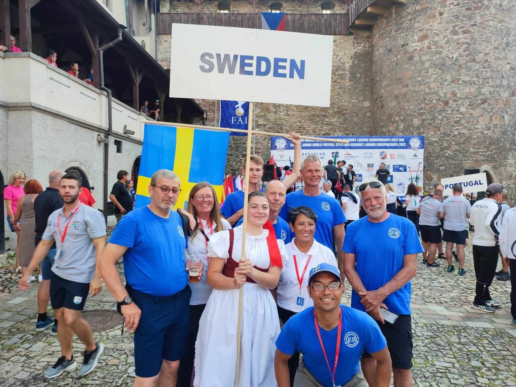 People with sign that says Sweden and a Swedish flag