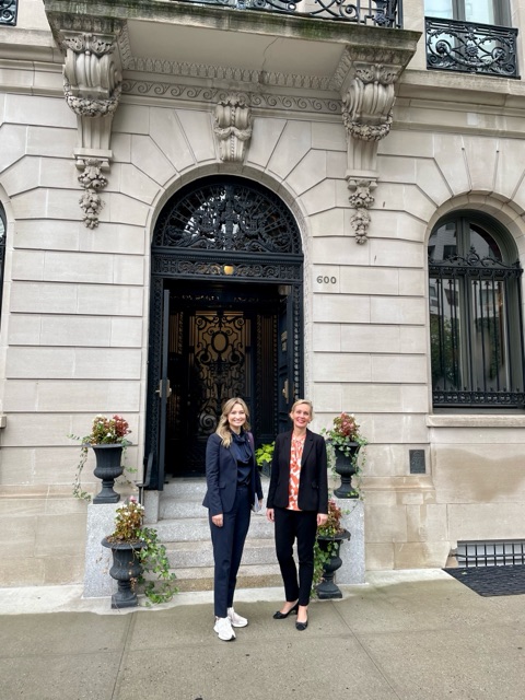 Two women standing in front of a building